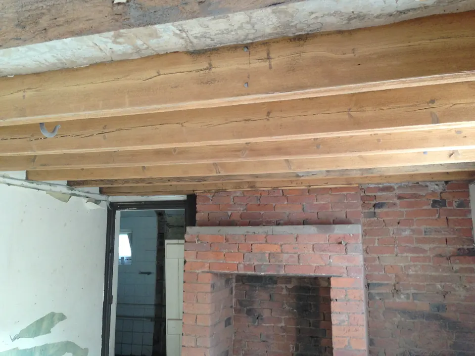 Oak ceiling beams and a brick fireplace after blast cleaning